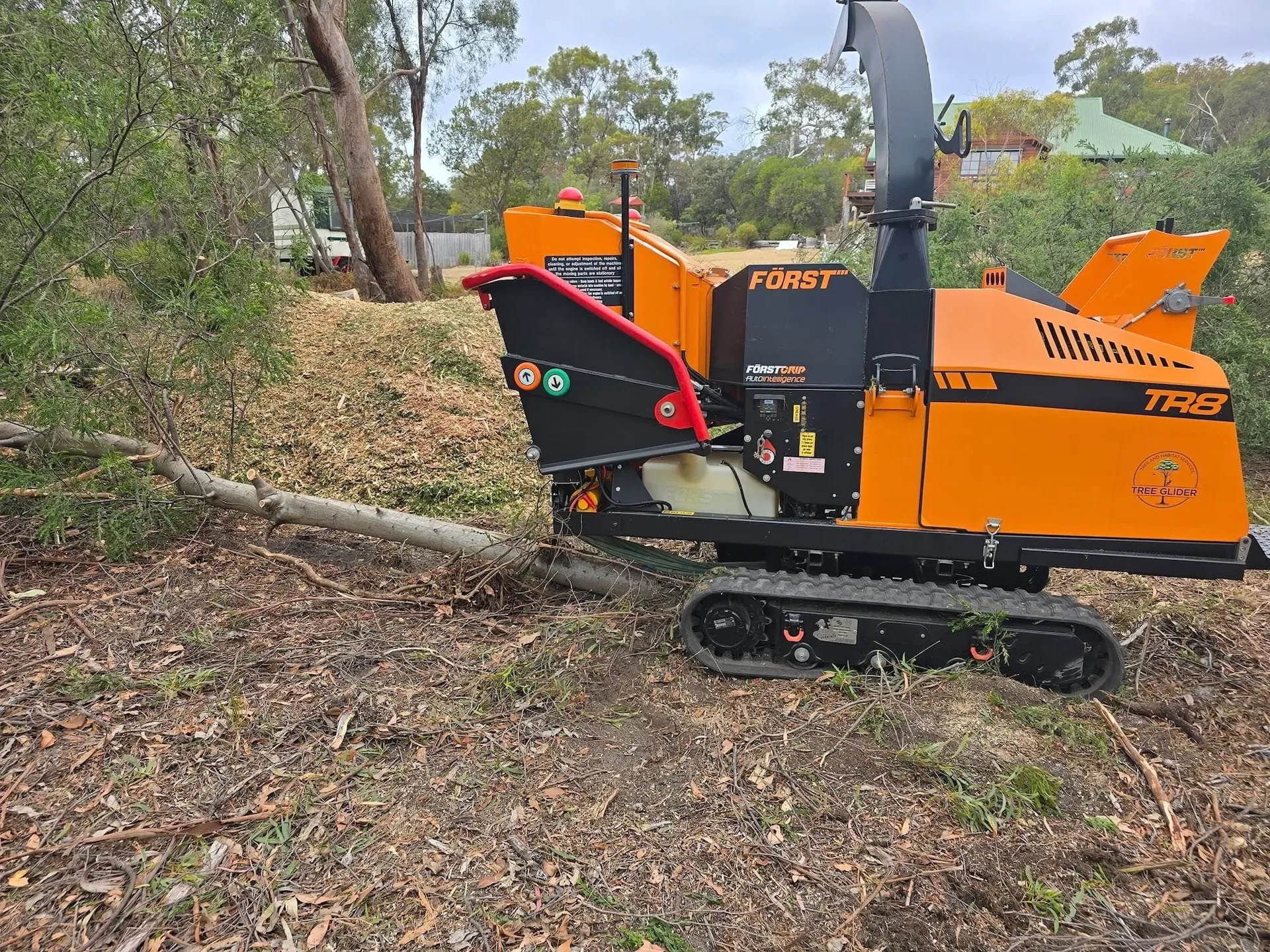 Wood chipper working beside felled timber on a bush block
