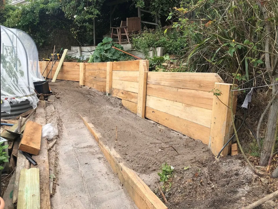 New timber sleeper retaining wall along a garden path