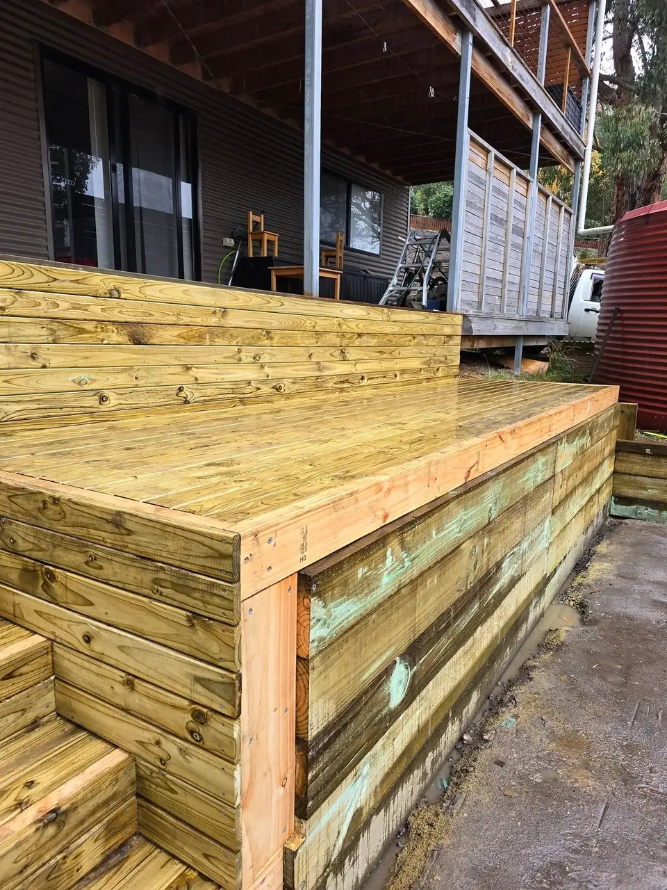Timber deck under construction beside a house