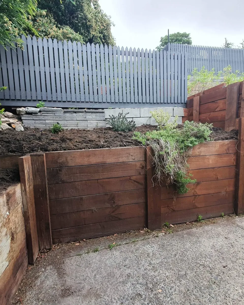 Tiered timber sleeper retaining walls beside a driveway